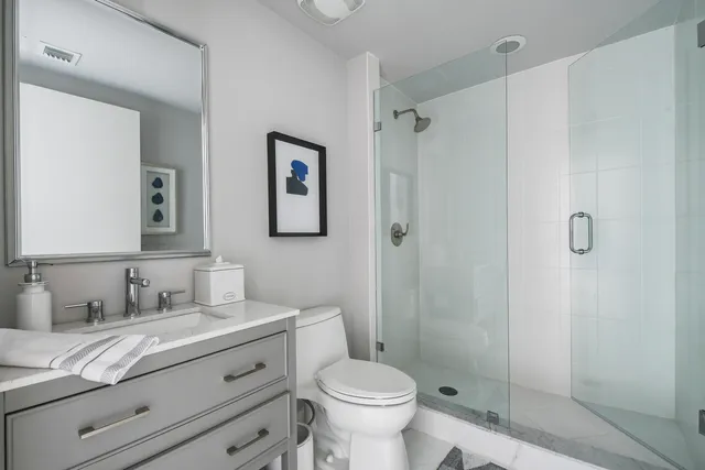 a bathroom with a granite countertop sink toilet and shower