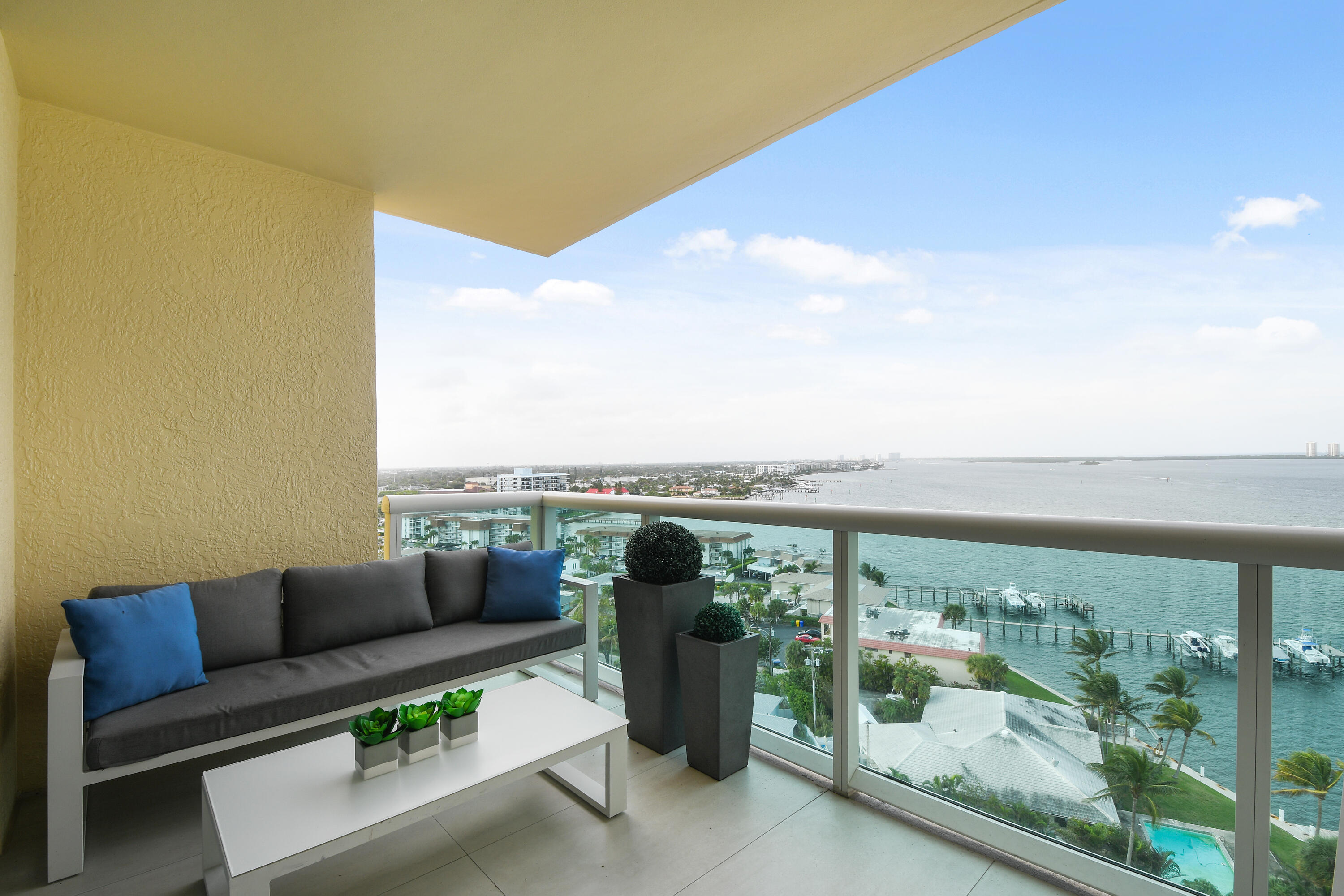 2650 Lake Shore Drive, Unit 1203 Riviera Beach, FL 33404 - Photo 16 of 17 a view of a balcony with couches and wooden floor