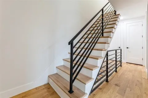 a view of a hallway with wooden floor and staircase
