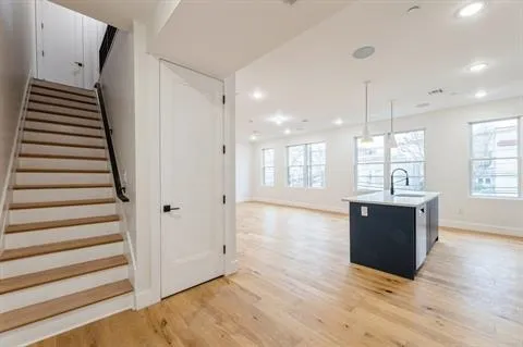 a view of an empty room with wooden floor and windows