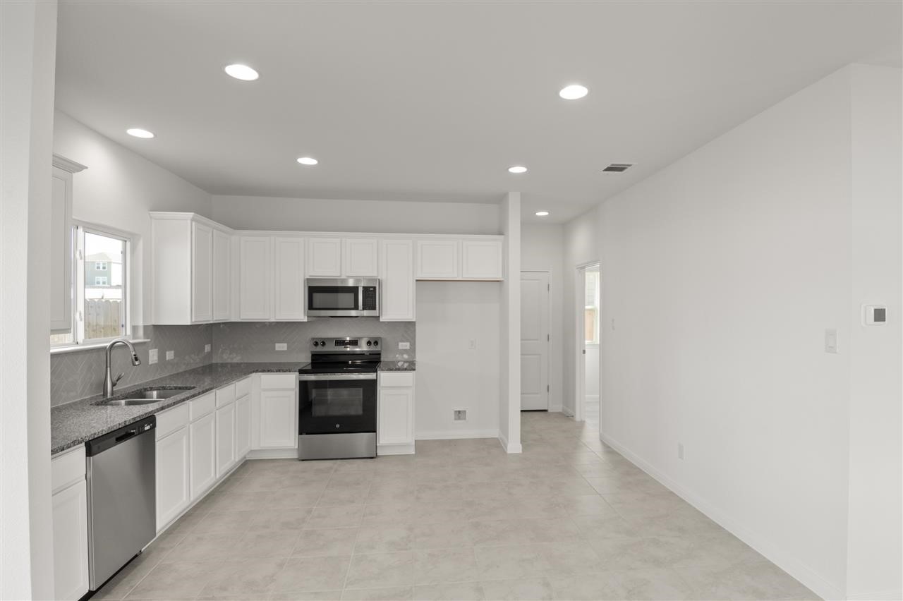 612 Yellow Ribbon Trail Jarrell, TX 76537 - Photo 1 of 1 Kitchen featuring sink, backsplash, white cabinets, and stainless steel appliances