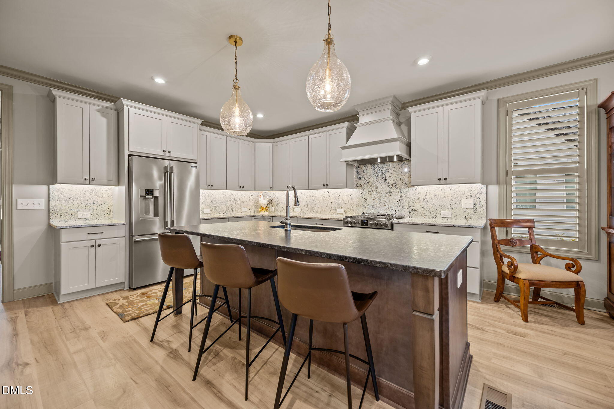 1748 Deacon Fls Way Wendell, NC 27591 - Photo 2 of 51 a kitchen with stainless steel appliances kitchen island granite countertop a dining table chairs and white cabinets