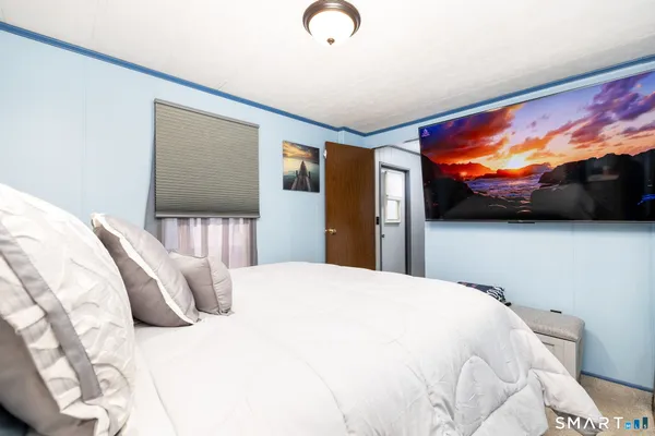 a bedroom with a bed and a flat screen tv