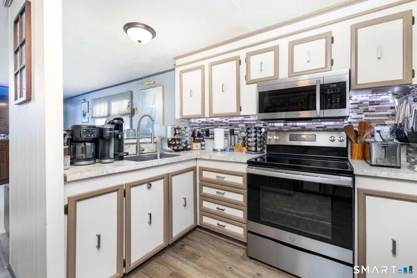 a kitchen with stainless steel appliances white cabinets and a stove top oven