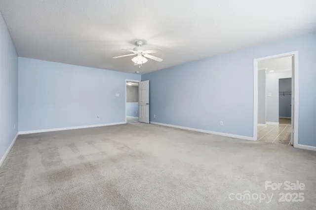 an empty room with a window and a ceiling fan