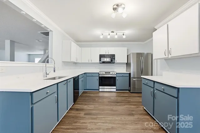 a kitchen with stainless steel appliances granite countertop a sink and a stove top oven