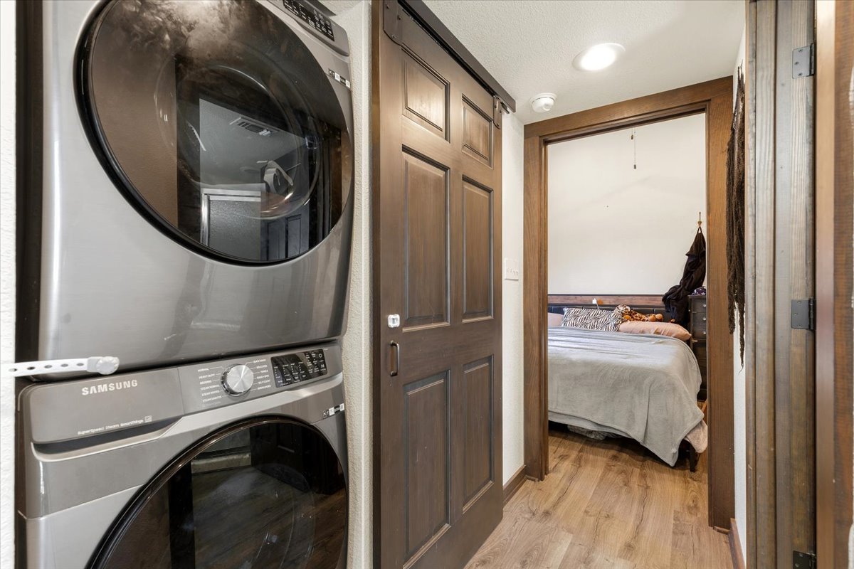 1705 Makinson Road West Point, TX 78963 - Photo 20 of 40 A clever space-saving stacked washer and dryer unit complements a charming interior barn door.