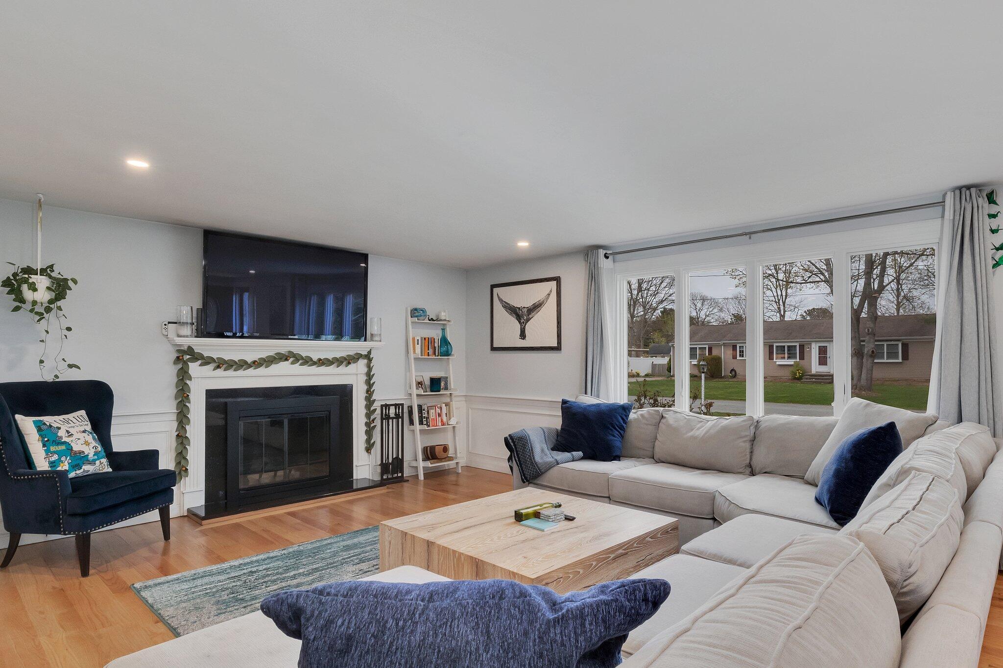 159 Sheaffer Road Centerville, MA 02632 - Photo 3 of 29 a living room with furniture a fireplace and a large window