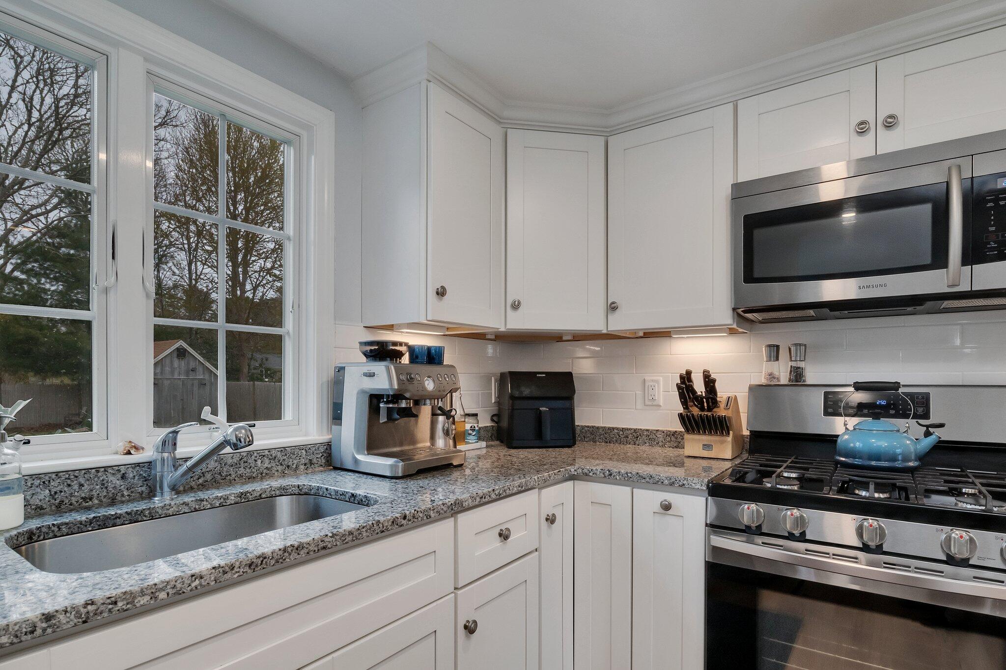 159 Sheaffer Road Centerville, MA 02632 - Photo 8 of 29 a kitchen with granite countertop a sink stainless steel appliances and cabinets