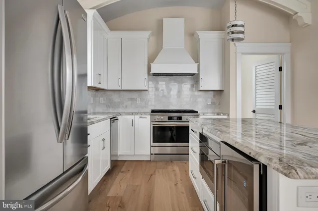 a kitchen with stainless steel appliances granite countertop a stove a sink and a refrigerator