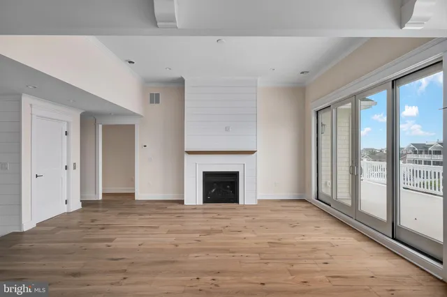 a view of an empty room with glass door and windows