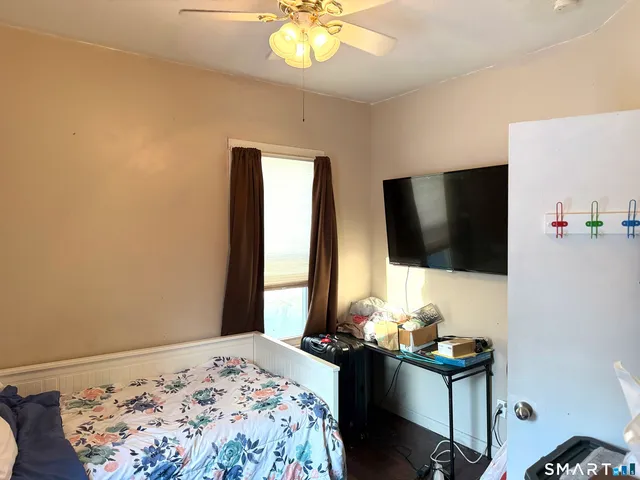 a bedroom with bed and a flat screen tv