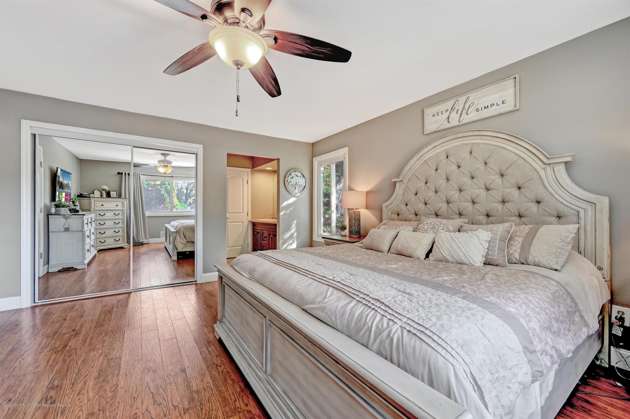 27 Sugar Bush Road Howell, NJ 07731 - Photo 27 of 46 a spacious bedroom with a large bed and a chandelier