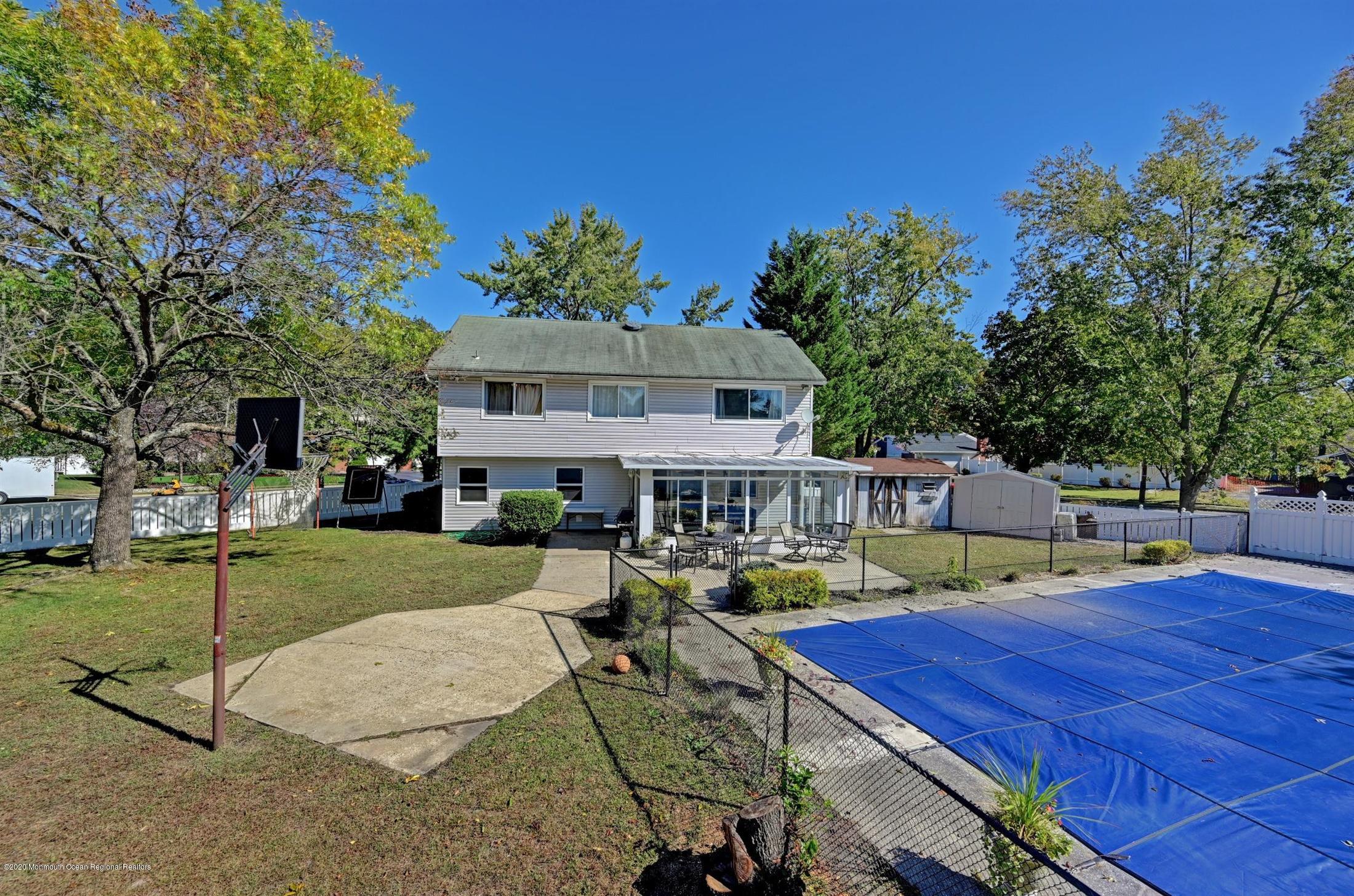 27 Sugar Bush Road Howell, NJ 07731 - Photo 43 of 46 a view of a patio with table and chairs potted plants and a palm tree