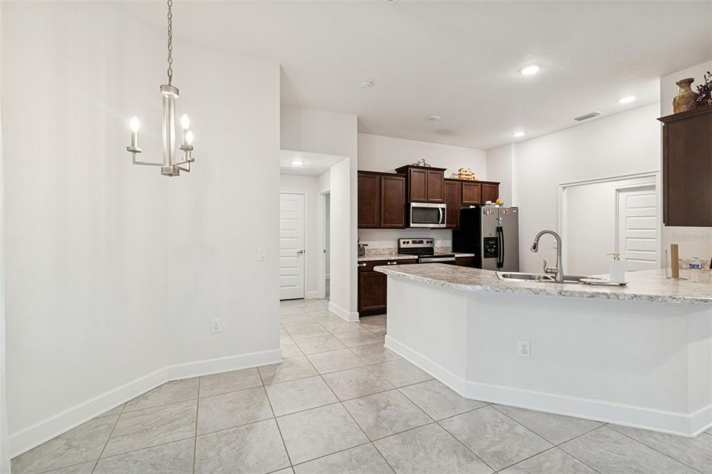 10358 Musa Road Spring Hill, FL 34608 - Photo 19 of 48 a large kitchen with granite countertop a sink a counter top space appliances and cabinets