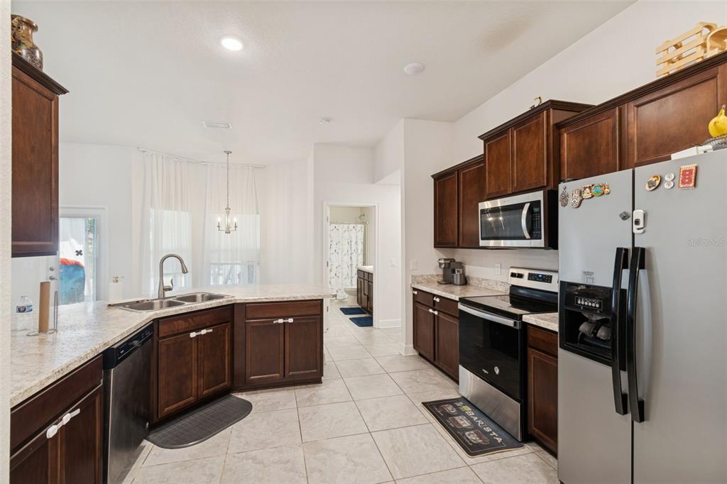 10358 Musa Road Spring Hill, FL 34608 - Photo 20 of 48 a kitchen with stainless steel appliances granite countertop a sink stove and refrigerator