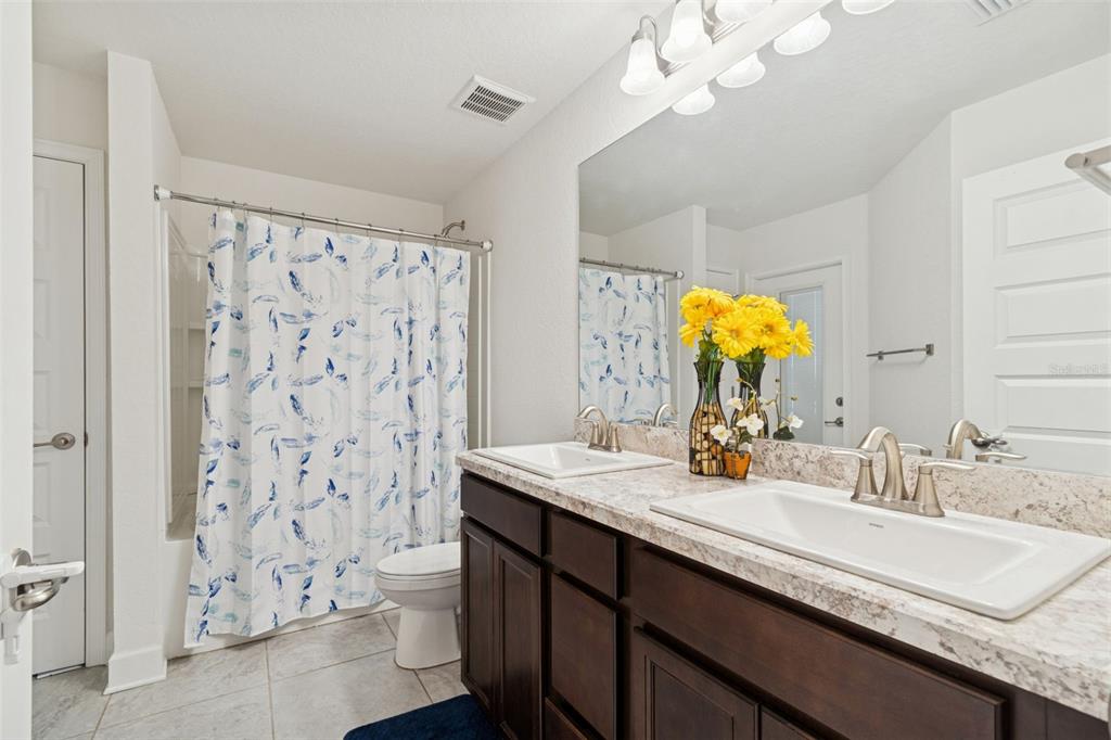 10358 Musa Road Spring Hill, FL 34608 - Photo 27 of 48 a bathroom with a double vanity sink mirror and shower
