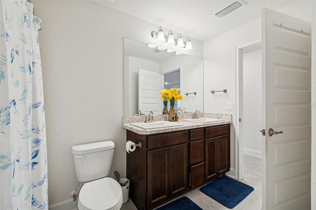 10358 Musa Road Spring Hill, FL 34608 - Photo 28 of 48 a bathroom with a sink a toilet and shower curtain