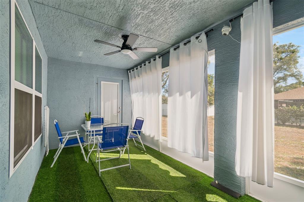 10358 Musa Road Spring Hill, FL 34608 - Photo 41 of 48 a living room with a floor to ceiling window and a table