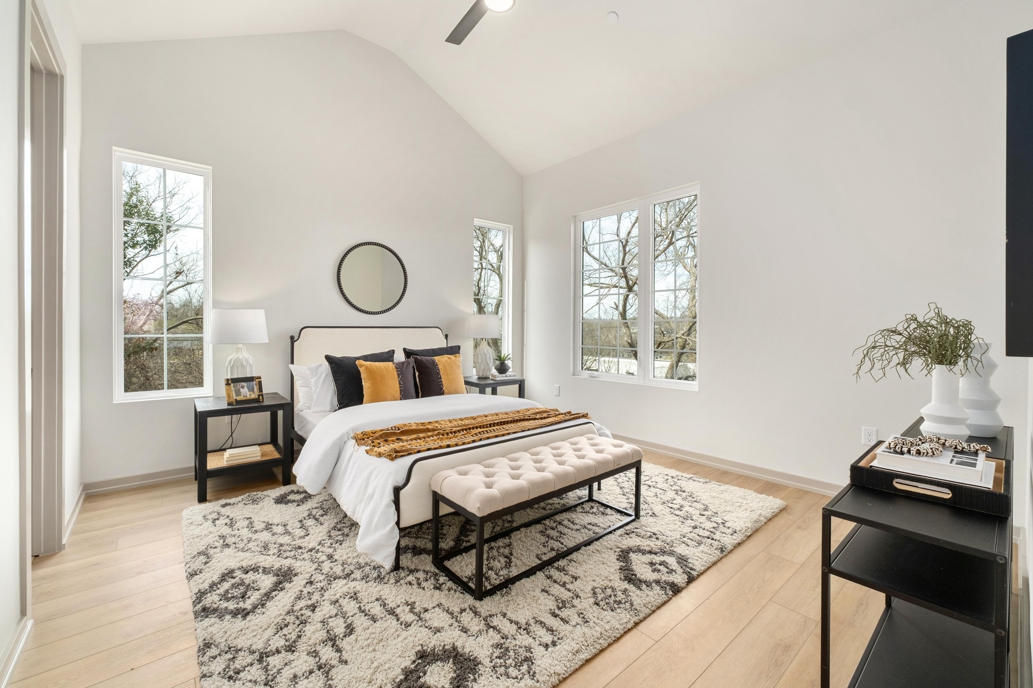 1736 Bunche Road, Unit B2 Austin, TX 78721 - Photo 3 of 37 Upstairs, light hardwood flooring continues throughout, creating a cohesive and calming feel. All bedrooms feature tall vaulted ceilings, adding volume and airiness. The primary retreat feels intentionally serene, with a spacious walk-in closet and a spa-inspired bathroom featuring dual vanities and an impressive walk-in shower wrapped in floor-to-ceiling tile. Two additional bedrooms share a well-appointed bath with a dual-sink vanity, perfect for guests or flexible living.