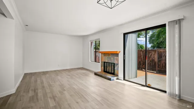 a view of a livingroom with wooden floor and a fireplace