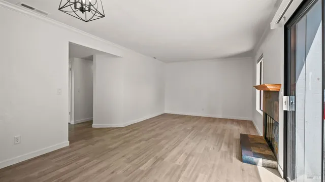 an empty room with wooden floor and a window