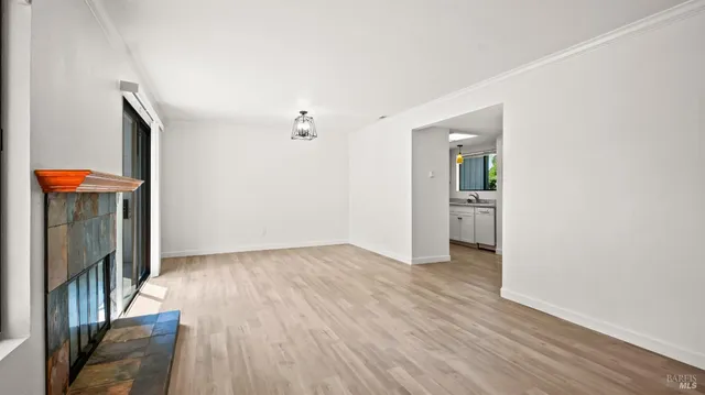 an empty room with wooden floor and fireplace