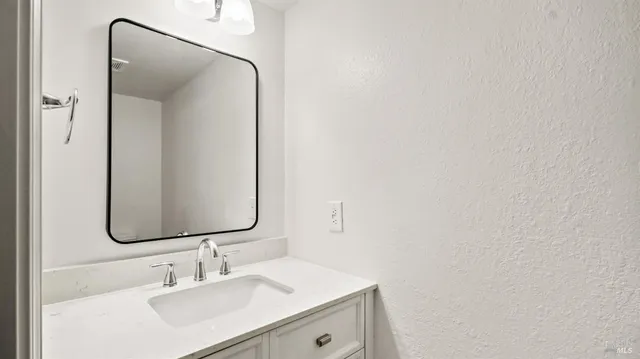 a bathroom with a sink vanity and a mirror