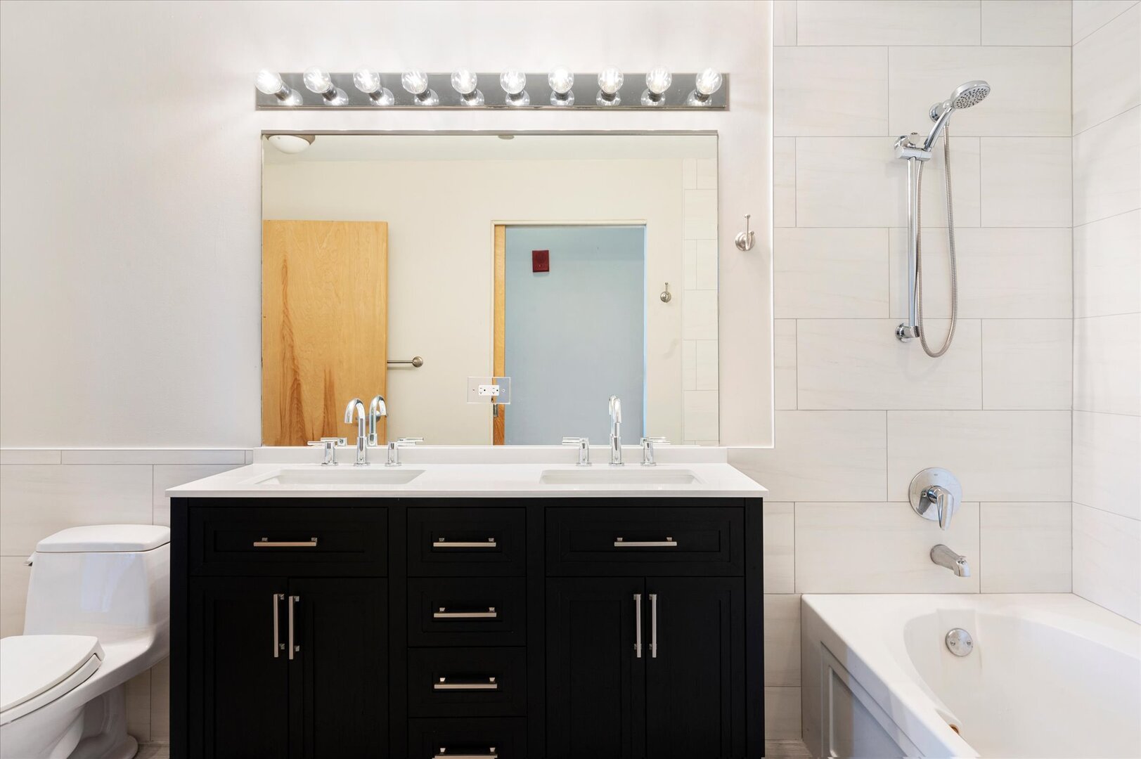 1720 South Michigan Avenue, Unit 1712 Chicago, IL 60616 - Photo 12 of 33 a view of a bathroom with a sink mirror and bathtub