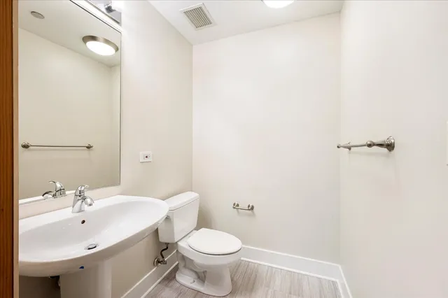 a bathroom with a sink toilet and a mirror