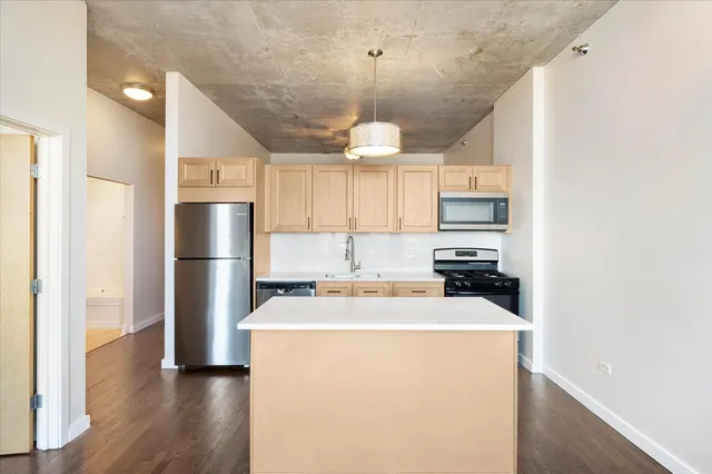 a kitchen with refrigerator a microwave and cabinets