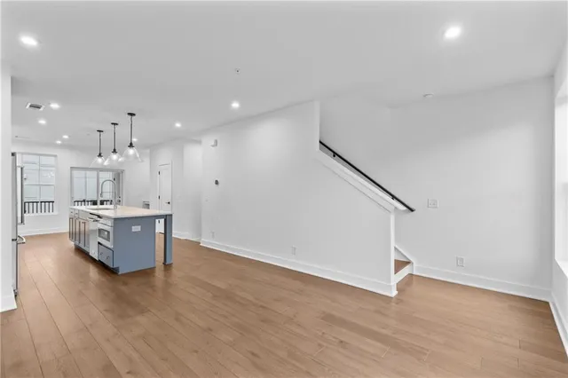 a view of kitchen with stainless steel appliances cabinets and wooden floor