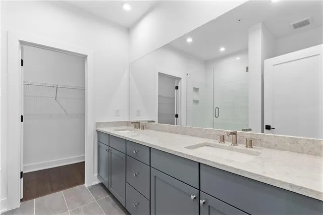 a bathroom with a granite countertop sink double and mirror