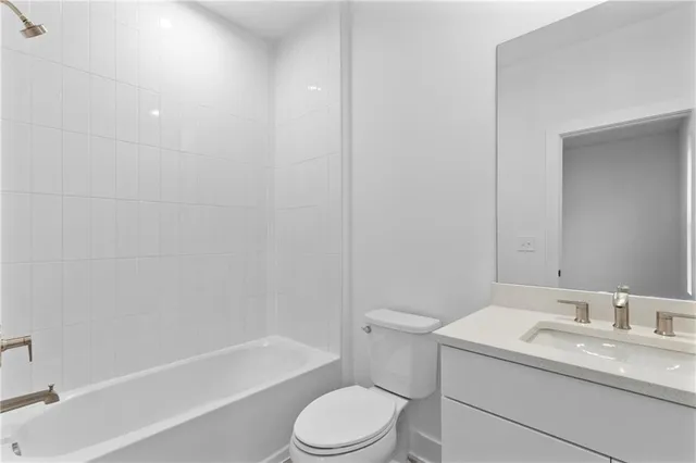 a bathroom with a granite countertop toilet a sink and a bathtub