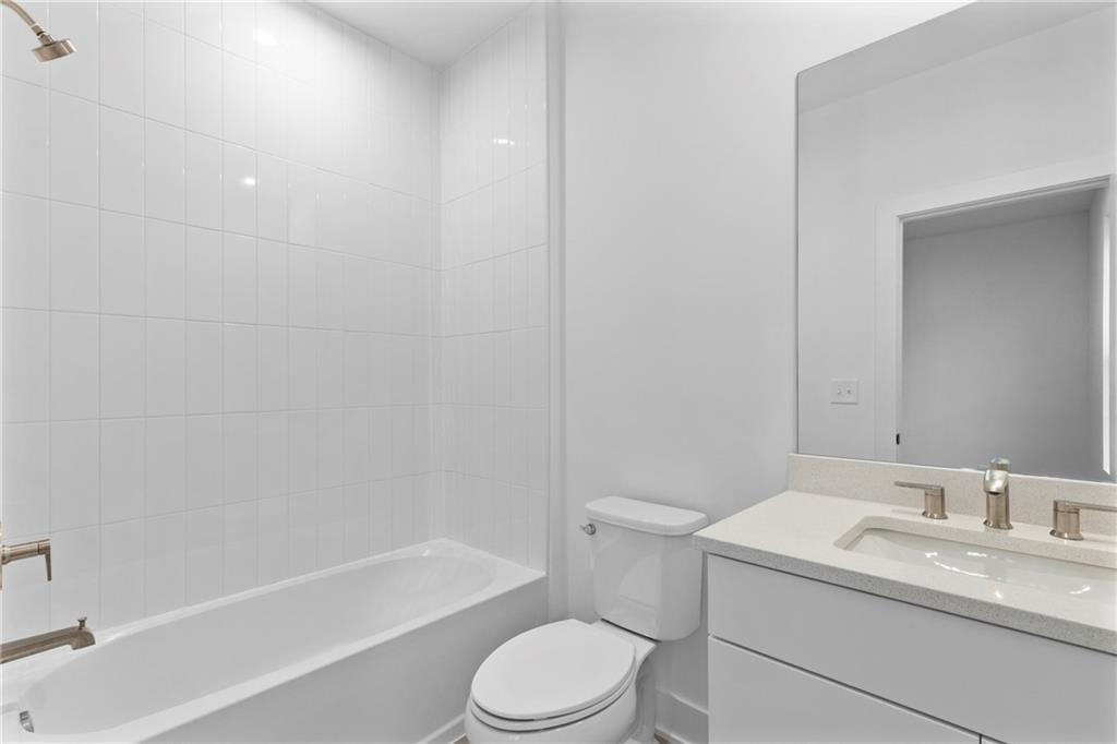 201 New Street, Unit 2304 Decatur, GA 30030 - Photo 23 of 28 a bathroom with a granite countertop toilet a sink and a bathtub