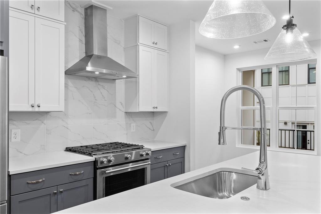 201 New Street, Unit 2304 Decatur, GA 30030 - Photo 8 of 28 a kitchen with stainless steel appliances granite countertop a sink a stove and a wooden cabinets