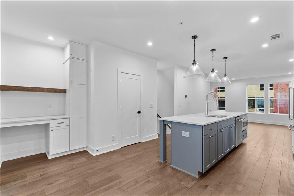 201 New Street, Unit 2304 Decatur, GA 30030 - Photo 10 of 28 a large kitchen with stainless steel appliances granite countertop a large counter top and a wooden floors