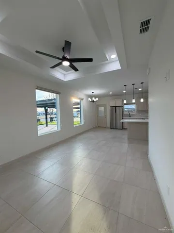 a view of a livingroom and a chandelier fan and windows
