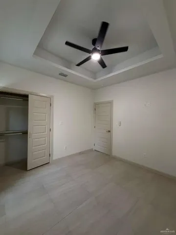 an empty room with a ceiling fan and a window