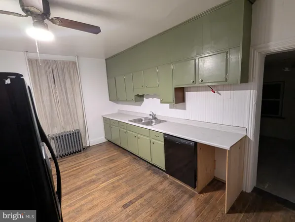 a room with a sink wooden floor and a mirror