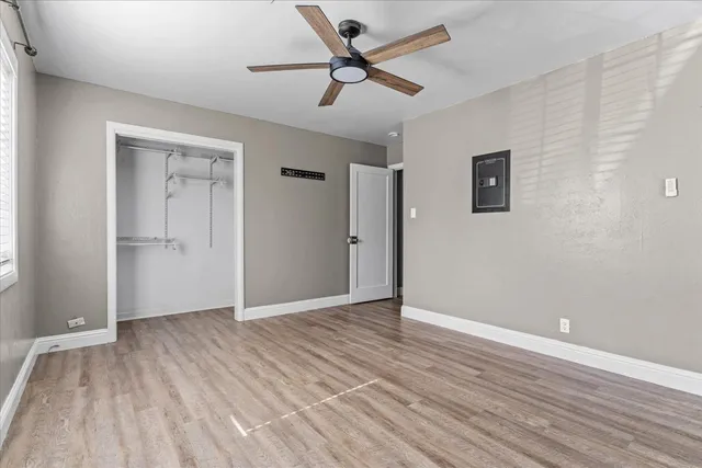 an empty room with wooden floor and windows