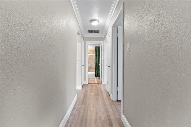a view of a hallway with wooden floor