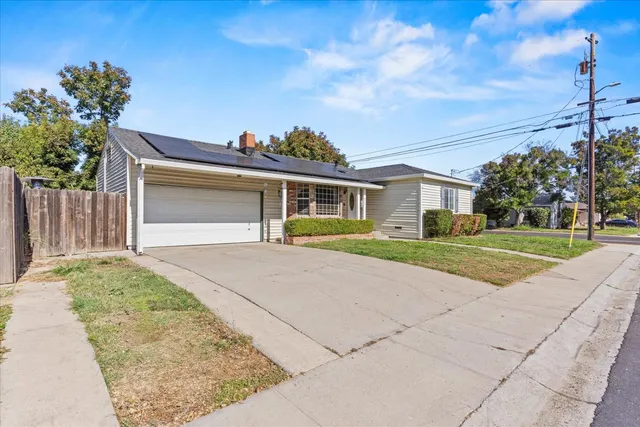 a front view of a house with a yard and potted plants