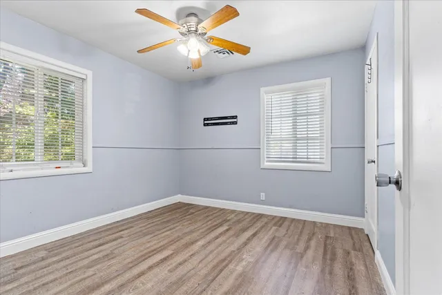 a view of a room with wooden floor and a window