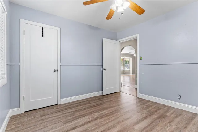 an empty room with wooden floor and windows