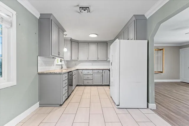 a kitchen with stainless steel appliances granite countertop a refrigerator and a stove
