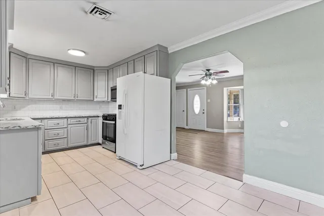 a kitchen with a refrigerator a stove top oven and cabinets