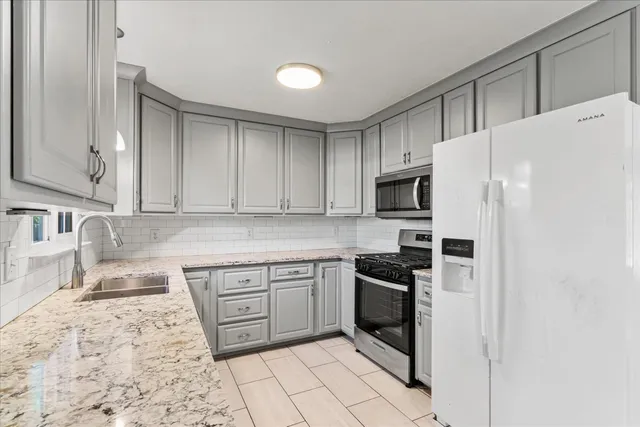 a kitchen with stainless steel appliances granite countertop a refrigerator sink and cabinets