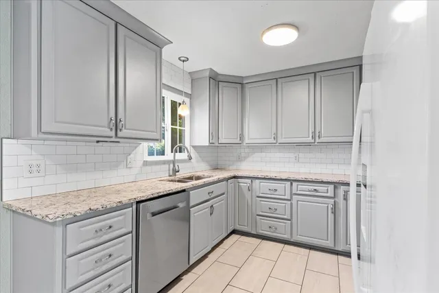 a kitchen with granite countertop cabinets sink and stove