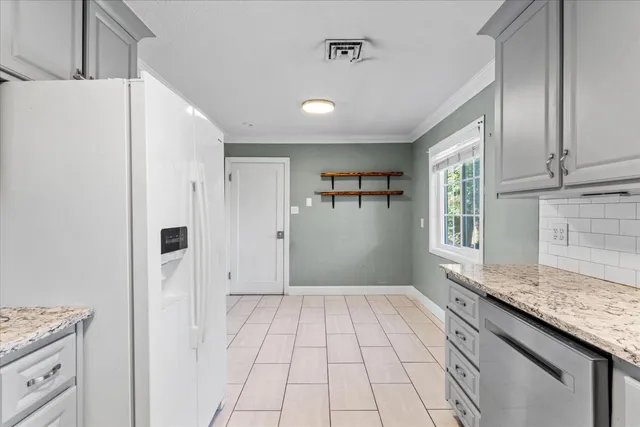 a view of kitchen with granite countertop cabinets appliances and a window